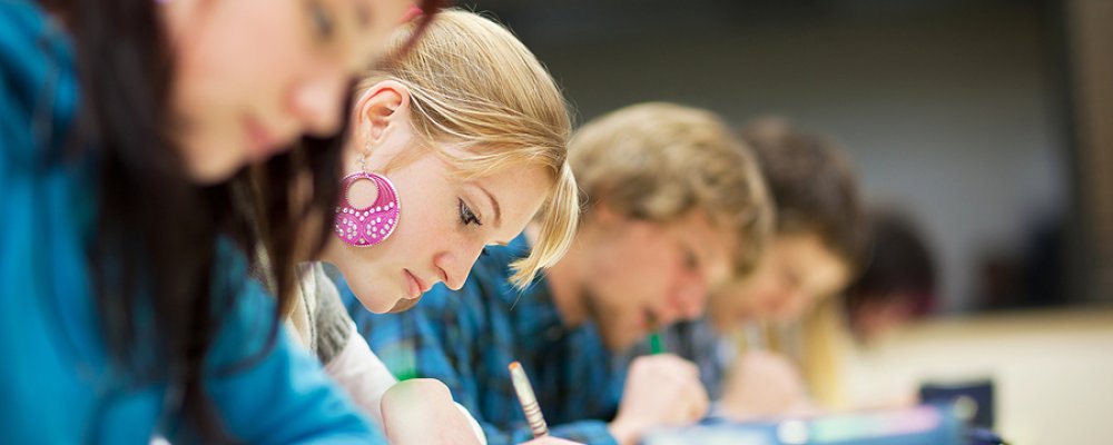 pretty female college student sitting an exam in a classroom ful Your Guide to the Texas Dream Act